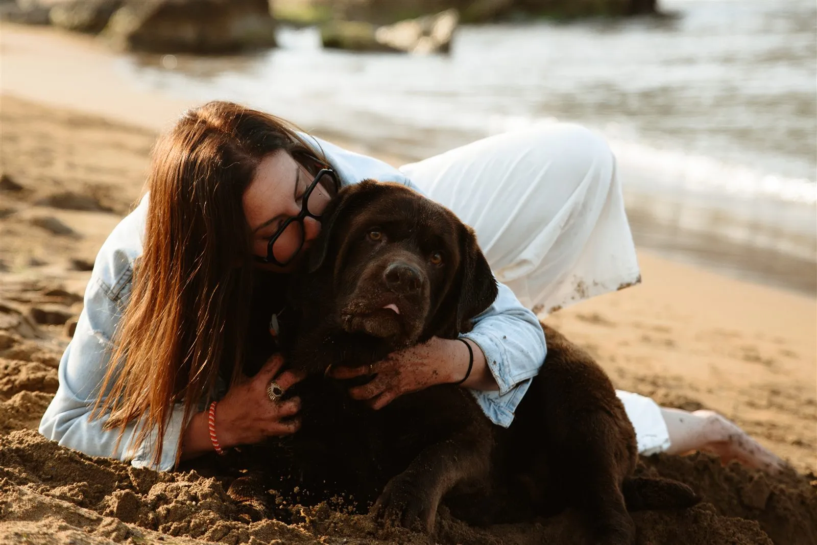 Inma abrazada a su perro Julio en la playa — Luarna Studio