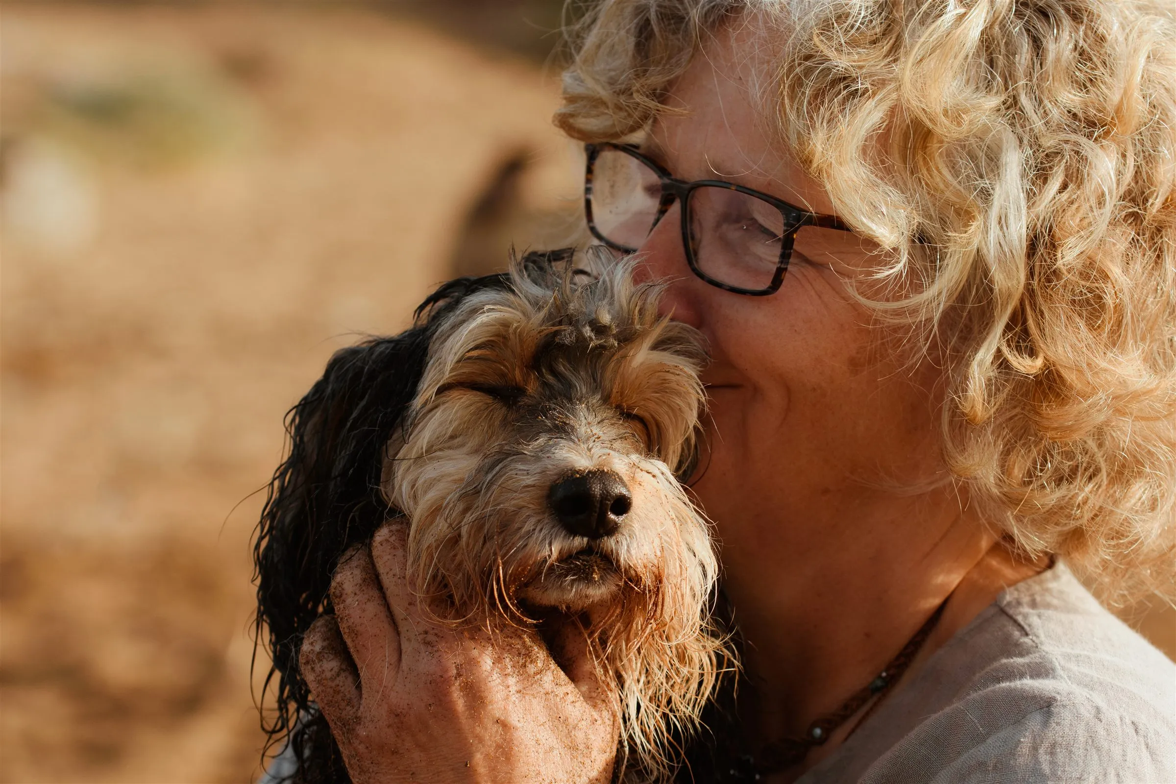 Fotógrafo de mascotas en Murcia: mujer abrazando a su perro mayor en la playa — Luarna Studio